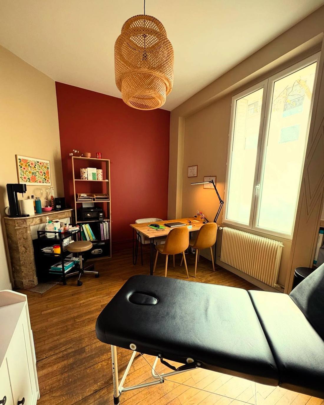 Salle de soin chaleureuse du cabinet An-K+, mur terracotta et parquet ancien